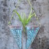 Handcrafted wooden wall hanging planter in a unique V-shaped design, perfect for adding a touch of nature-inspired elegance to your home decor. The planter features intricate carving details and a sturdy construction, providing a stylish and functional way to display your favorite indoor plants. Its artistic craftsmanship and natural wood finish effortlessly blend with various interior styles, bringing a refreshing and organic feel to any room."