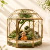 Geometric dome glass house terrarium with Buddha figurine and succulent plants by Wildroots Gifting for desktop décor and gifting across India via gifting.wildroots.in.