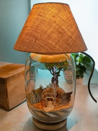 Bell jar lamp terrarium with plants and moss by Wildroots.